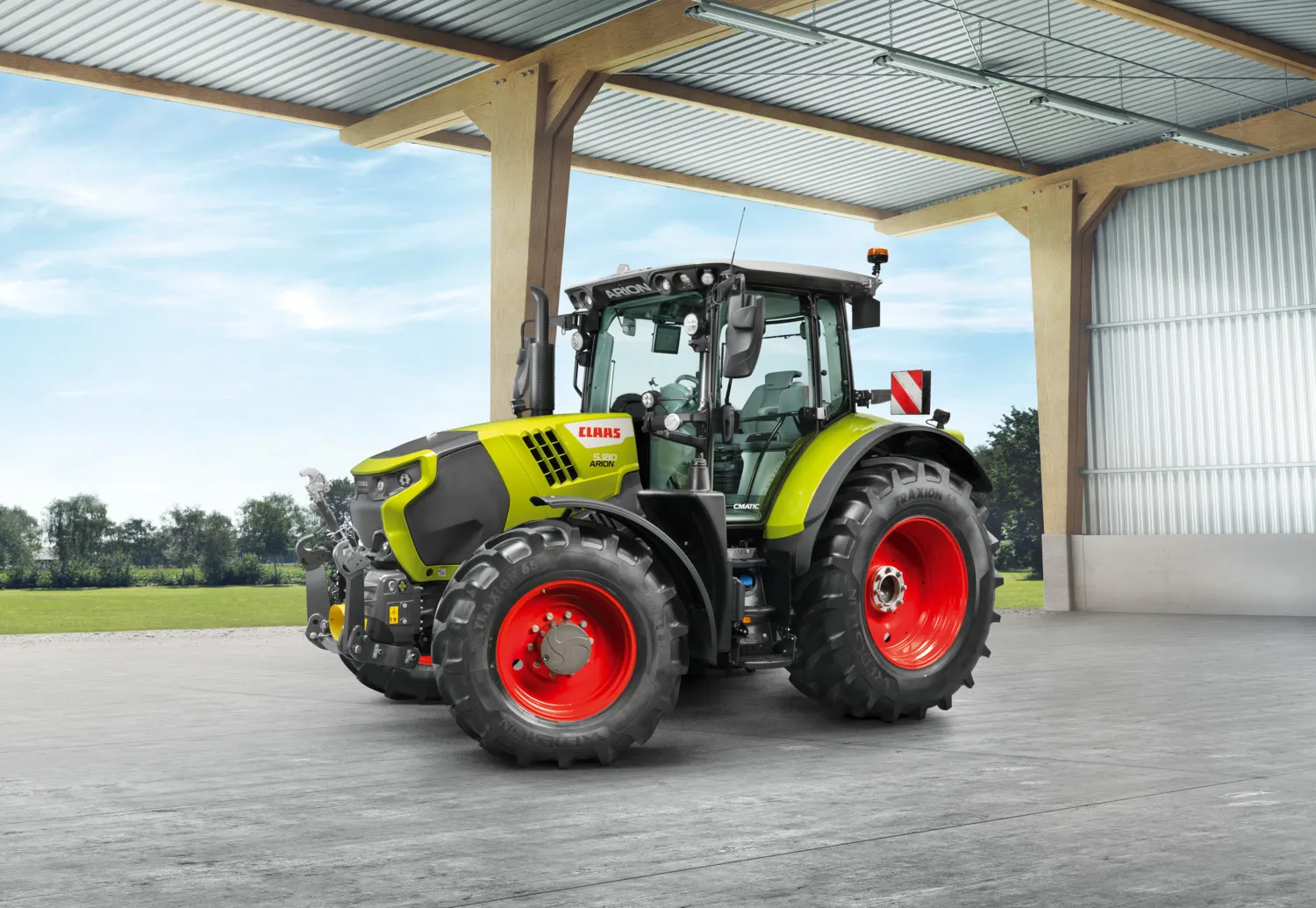 CLAAS ARION 5 CMATIC parkert ved en åpen maskinhall
