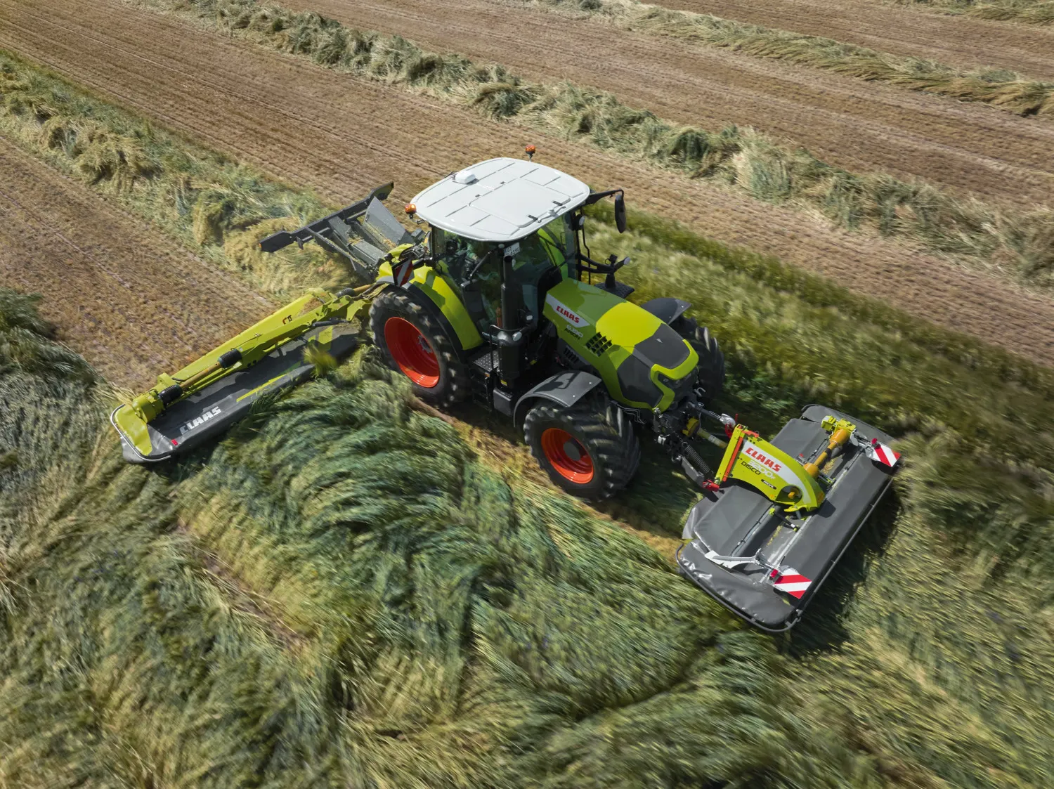 CLAAS-traktor med slåmaskiner foran og bak i grasarbeid