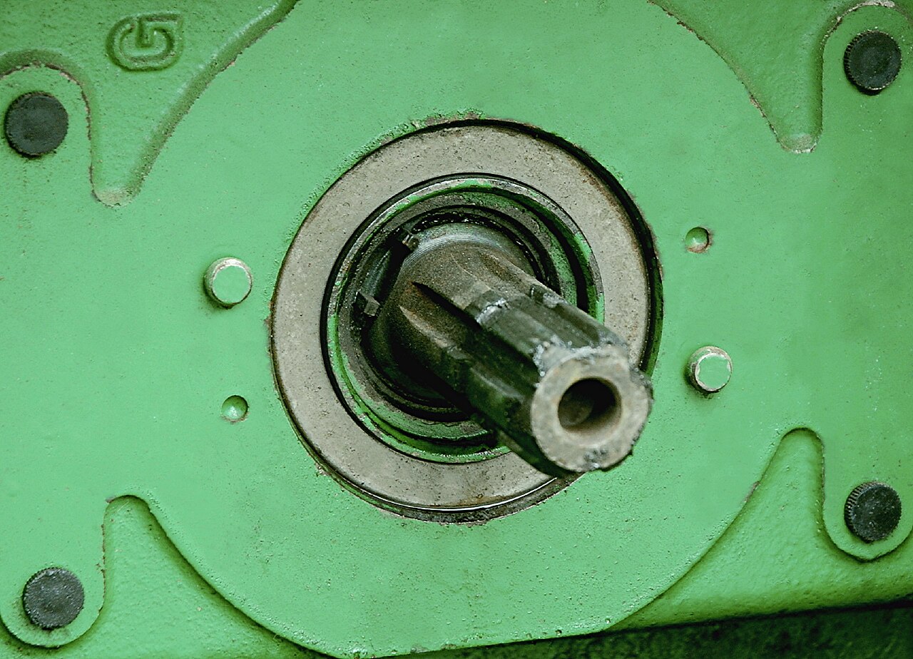 Nærbilde av en seks-splinet kraftuttakstapp bak på en John Deere-traktor