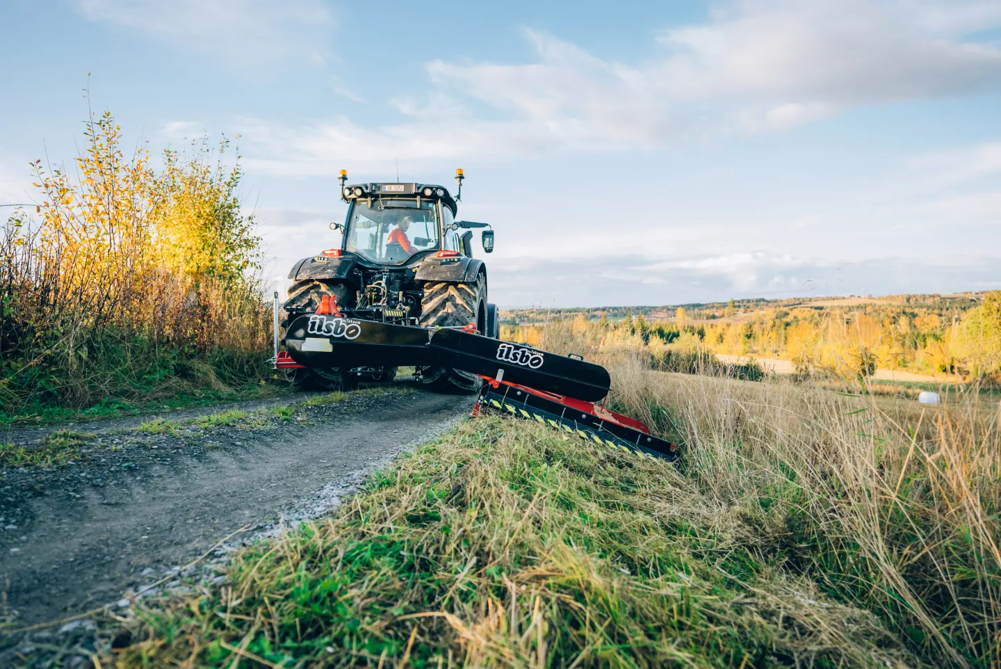 M160S krattknuser bak en traktor, med klippepannen ned mot veikanten