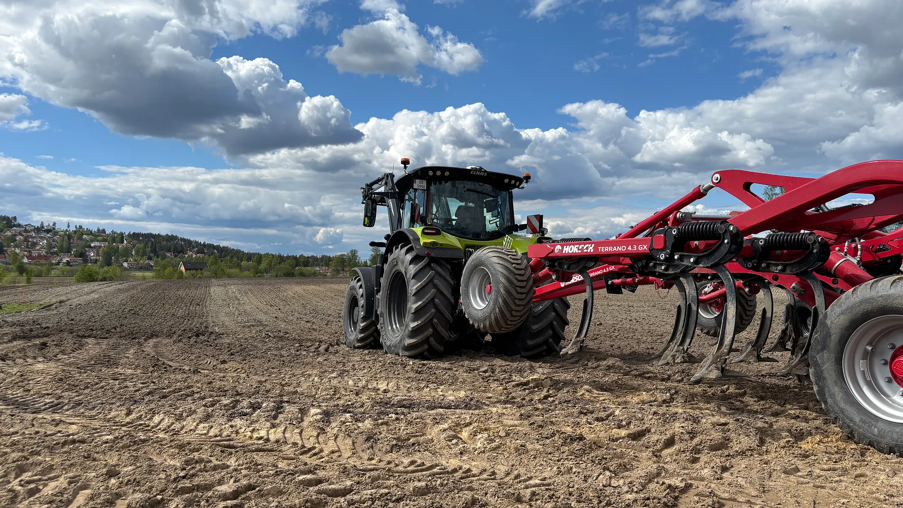 CLAAS-traktor trekker et rødt jordarbeidingsredskap på Herremyr gård