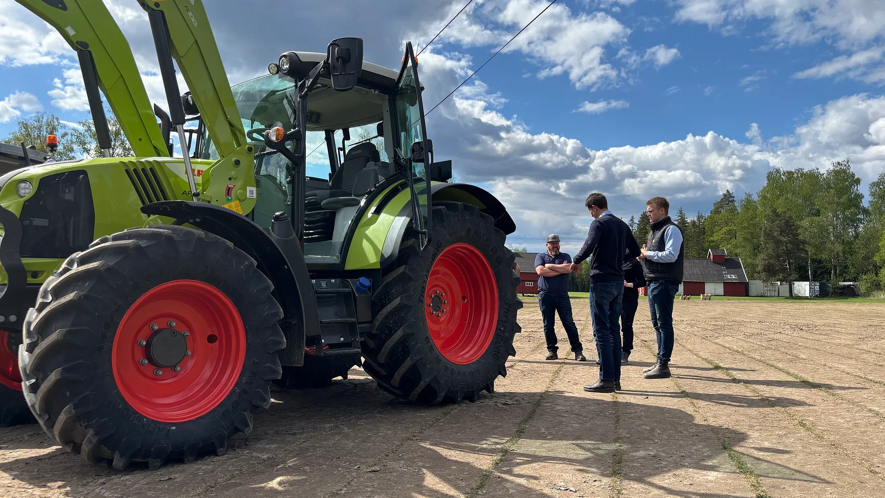 Fagfolk samlet ved en CLAAS-traktor med frontlaster på et norsk gårdstun