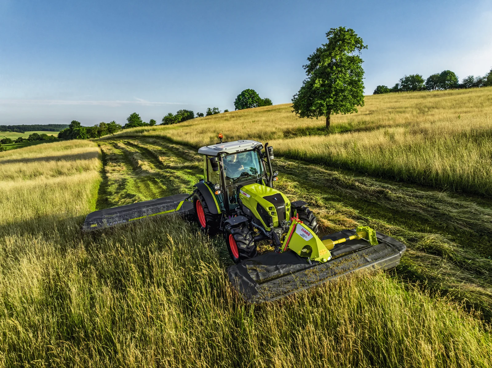 Traktor med frontmontert CLAAS DISCO-slåmaskin under slått
