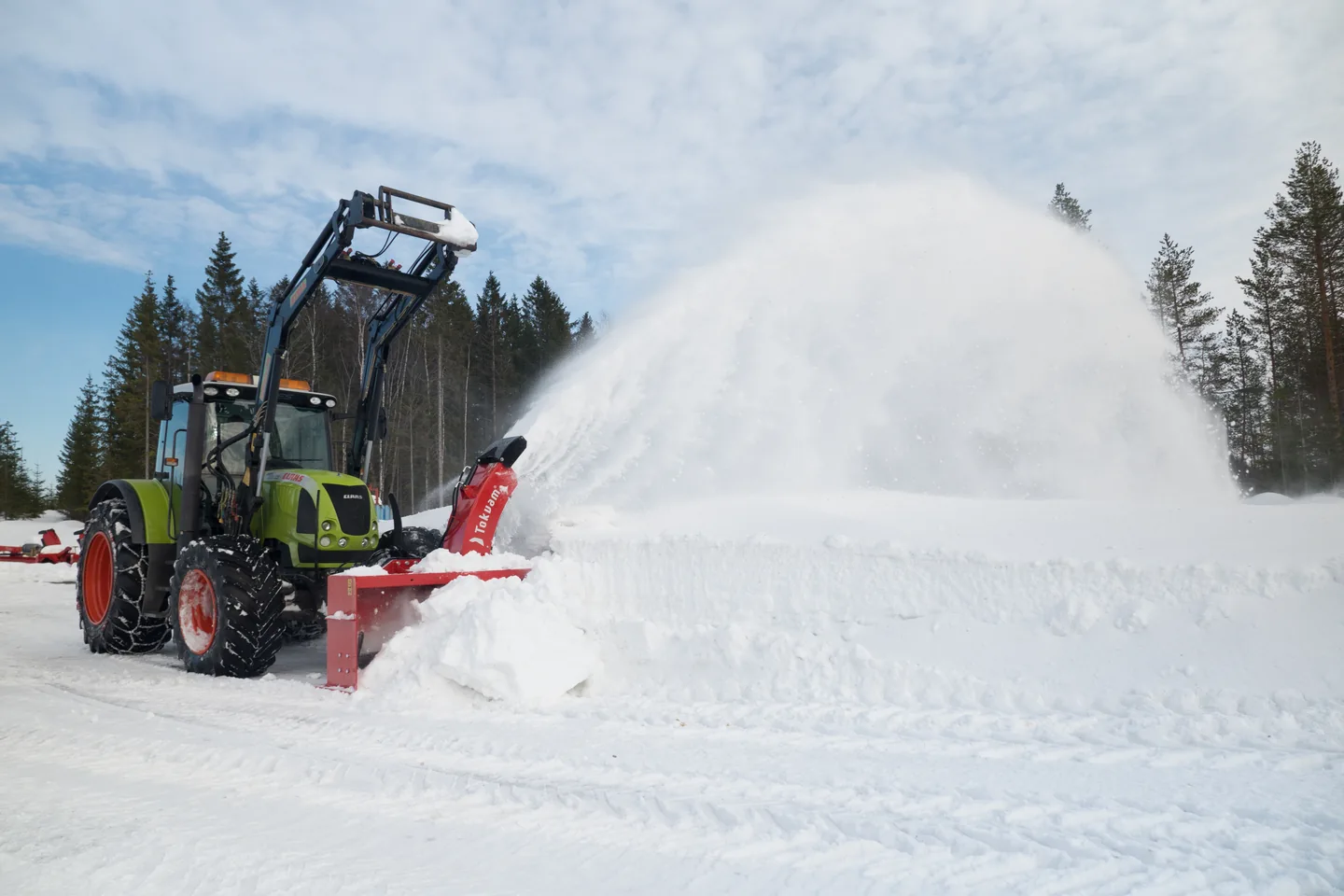 Grønn traktor med Tokvam 241 THS FLEX kaster snø til siden