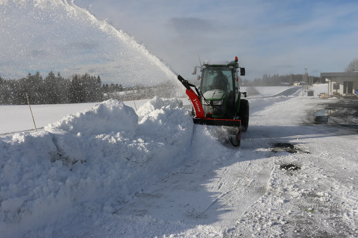 Frontmontert Tokvam F 180 THS rydder snø foran en liten traktor