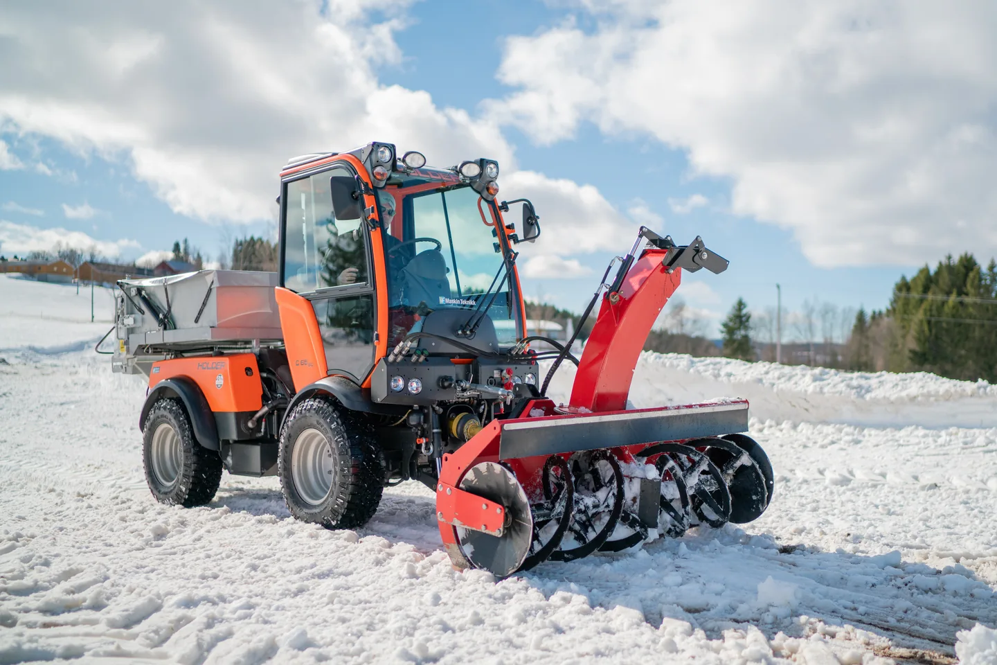 Rød Tokvam F 180 THS foran en oransje redskapsbærer i snø