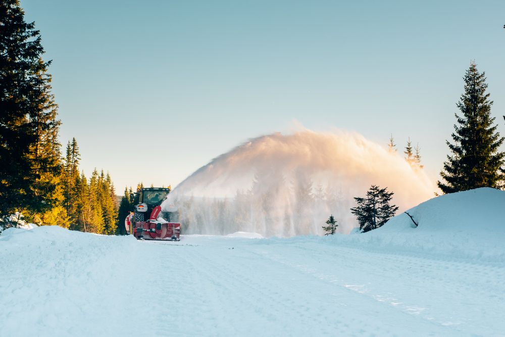 Traktor med Tokvam-snøfreser rydder en snødekt skogsvei