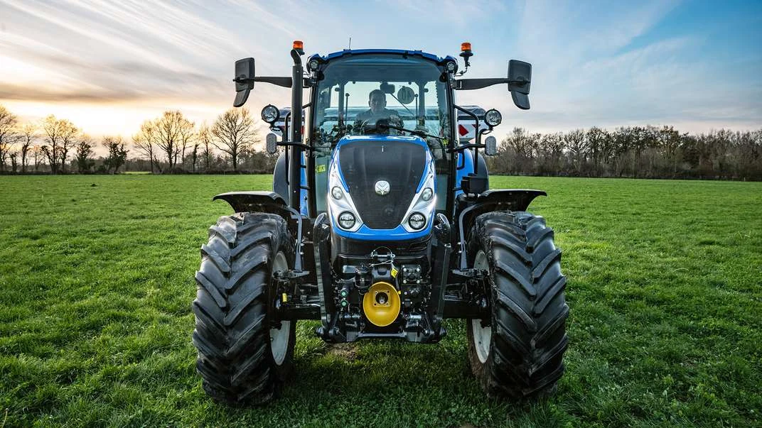 Nyere New Holland T5 Dual Command sett forfra på et grasjorde