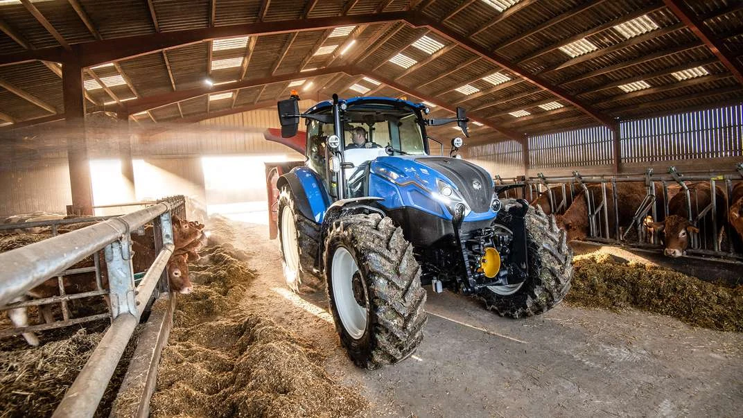 New Holland T5 Dual Command ved fôrbrettet i et husdyrbygg